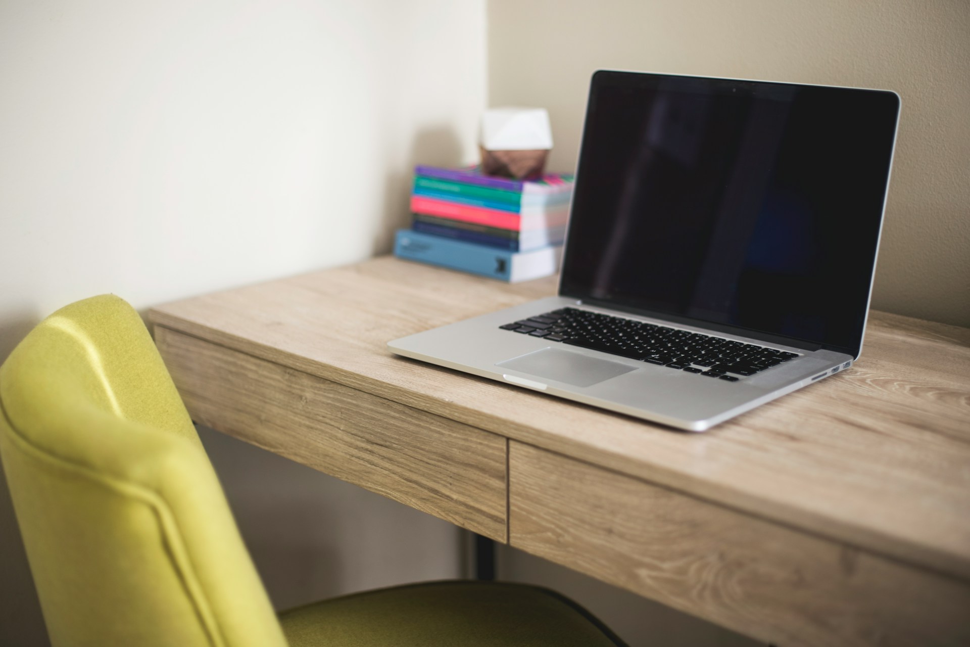 Laptop open on a small desk, ready for a video walkthrough of an apartment.