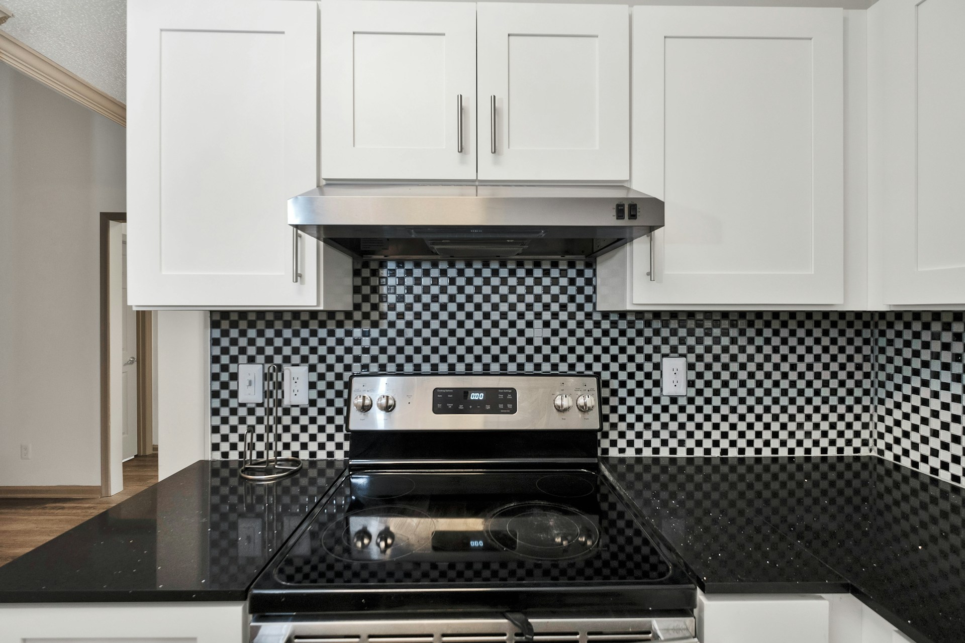 Stainless steel range under a range hood in a rental kitchen, the surfaces a cleaning deduction is argued over.