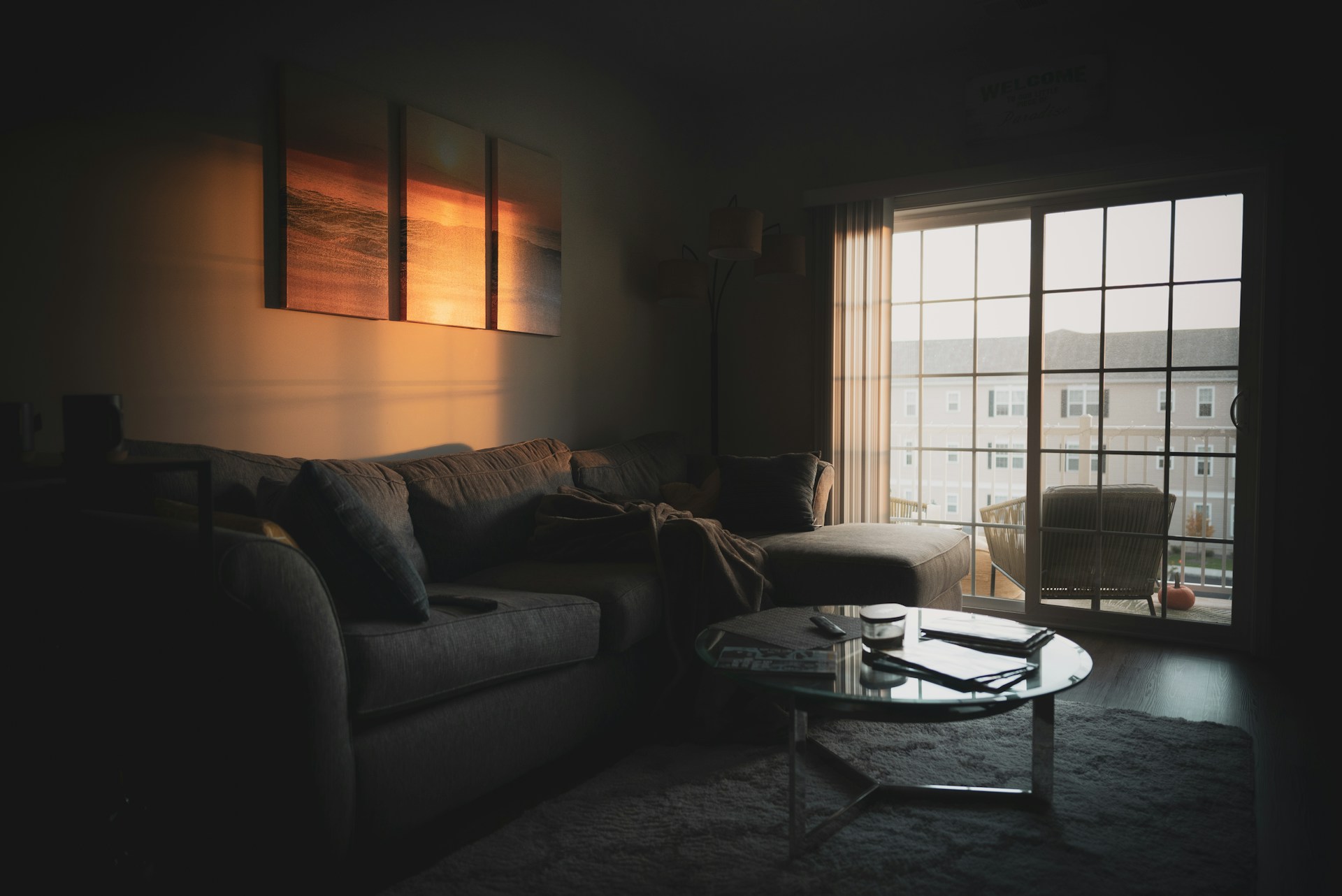 Furnished living room with a sectional sofa, coffee table and window in a lived-in apartment.