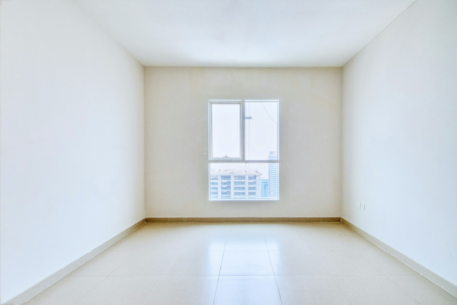 Bright empty room with a single window, the kind of space a light reading captures at one hour of the day.
