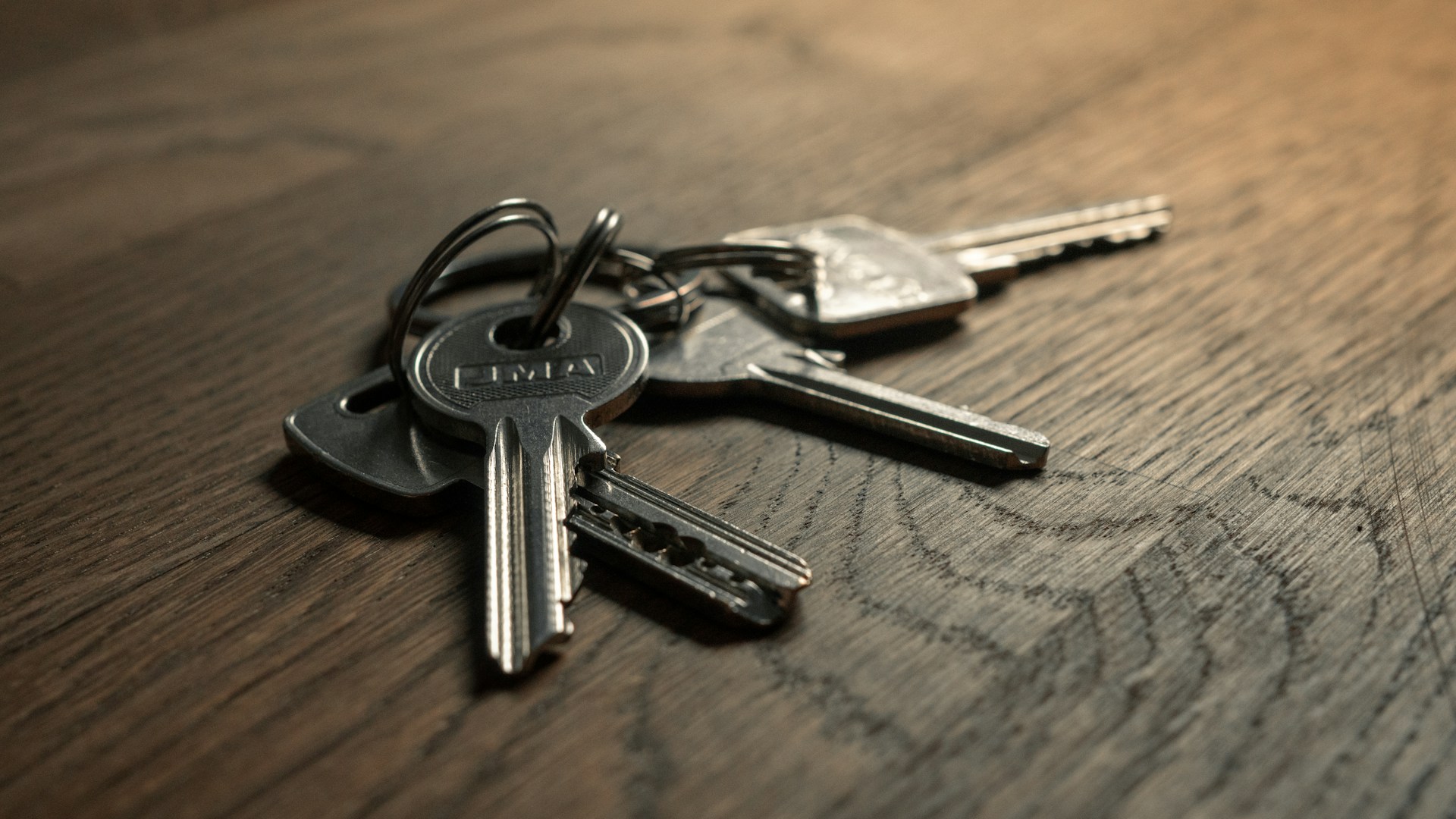 A bunch of apartment keys on a wooden table, before any deposit is paid.